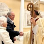 Holy Cross parishioners Pat and Ken Trojan greet Bishop Koenig after Christmas Eve Mass in Dover. Courtesy photo.